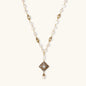 Y-shaped necklace with freshwater pearls, gold filigree stations, and ornate diamond-shaped centerpiece with pearl drop