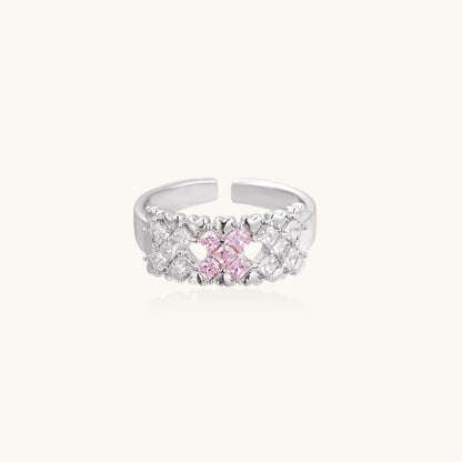 Close-up of an adjustable white gold plated ring featuring a cluster of square-cut clear and pink zirconia stones in geometric arrangement.